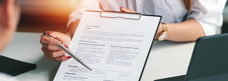 woman candidate and hr manager employer holding cover letter during job interview sitting in office